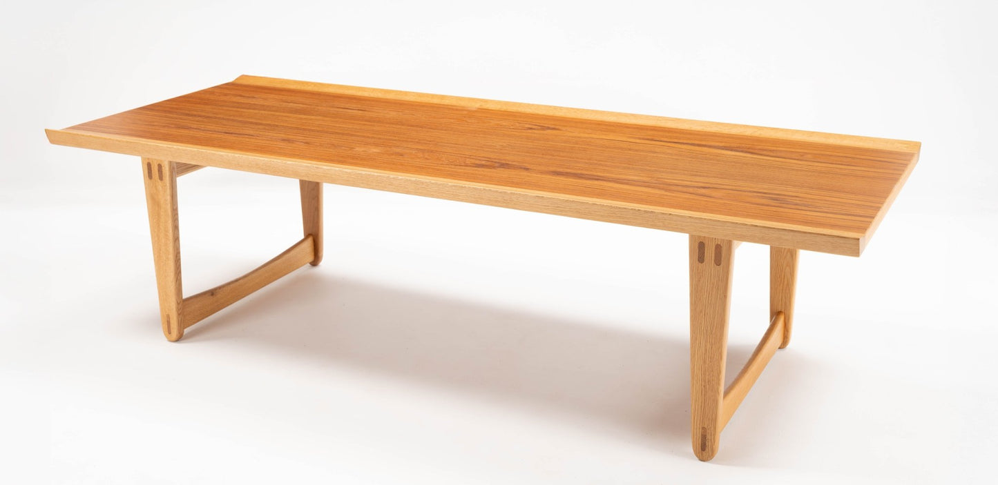 Mid-century modern Yngve Ekstrom coffee table in teak and oak with clean lines and joined legs on white background