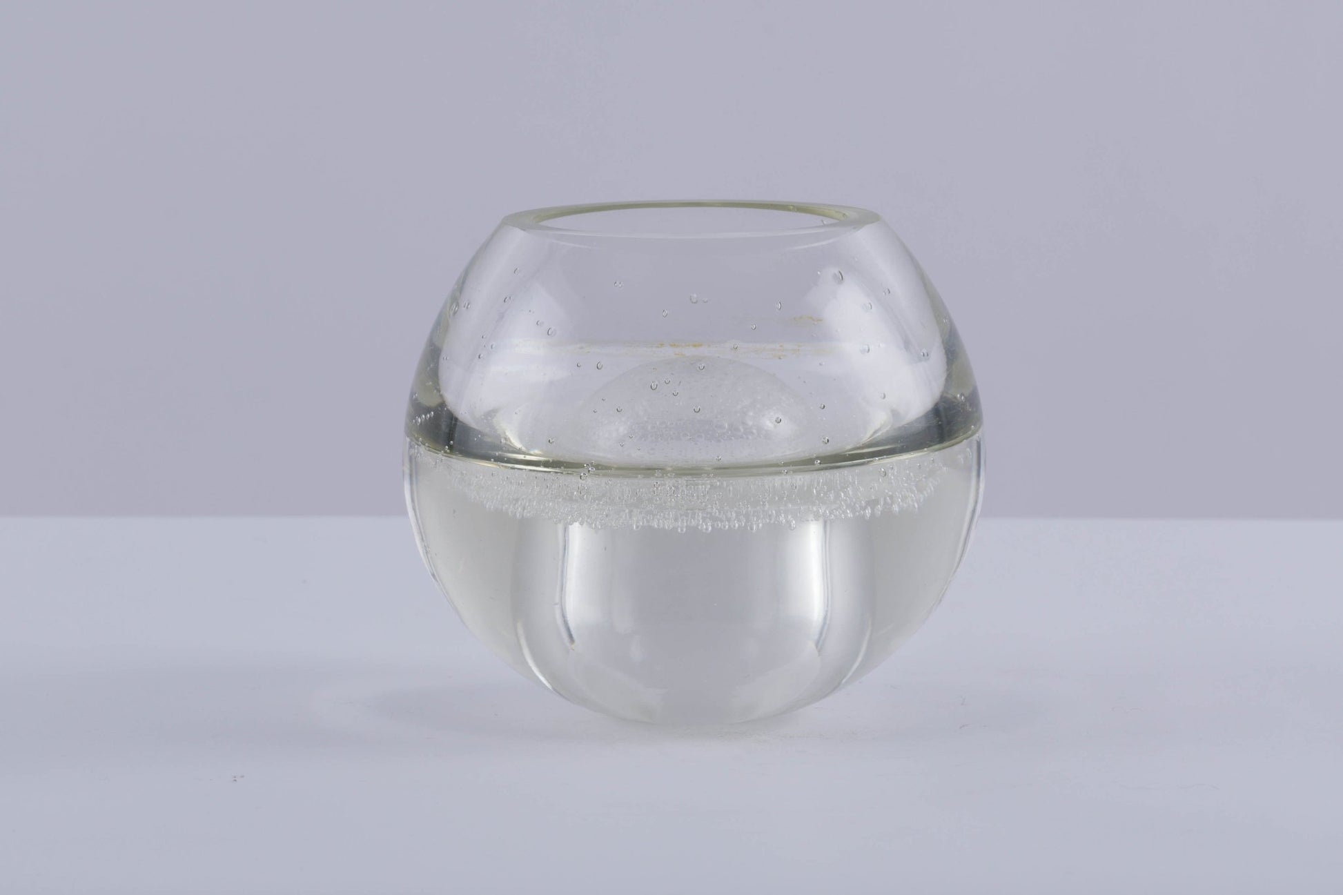A.D. Copier handblown glass vase with rounded shape and small air bubble details called Spijkerbol on gray background.