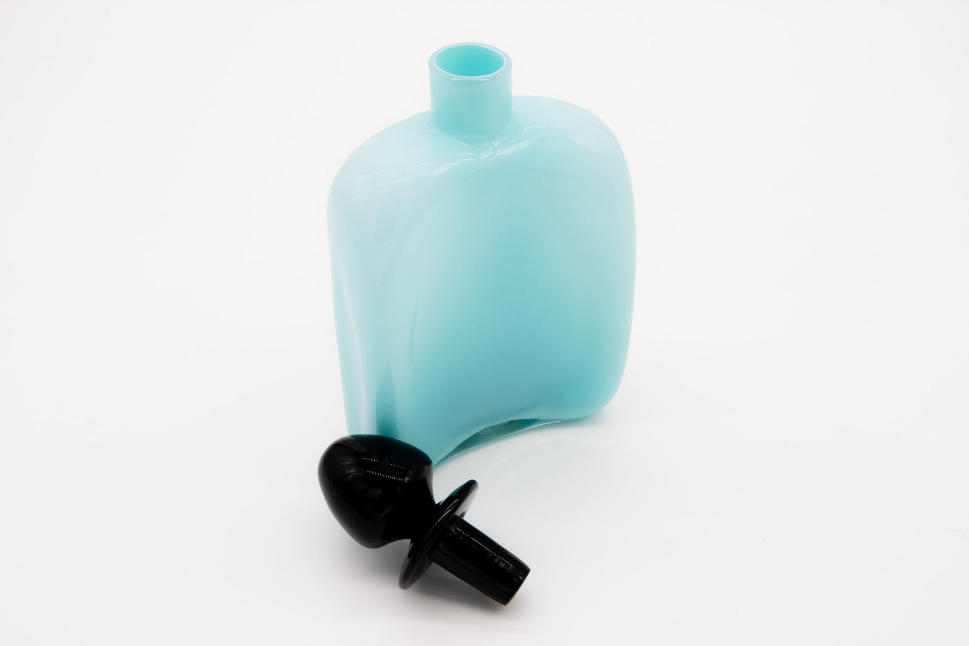 Carlo Moretti Murano glass decanter in light blue with black stopper, signed and labeled, elegant design.