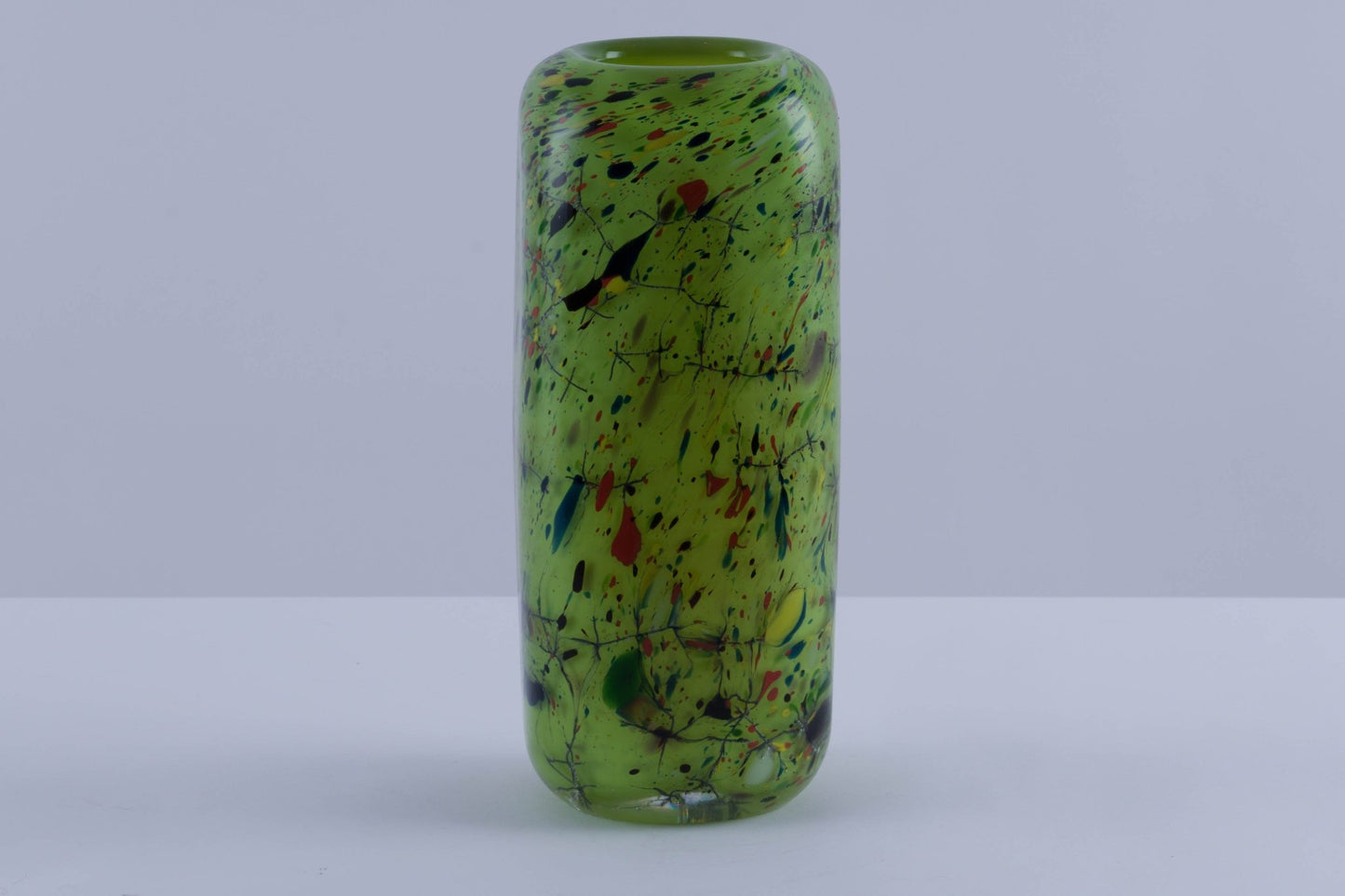 Rectangular colored glass vase with rounded edges, vibrant green and multicolor splatter design, thick heavy walls.