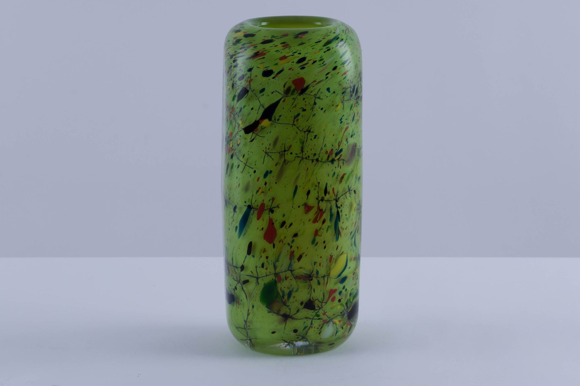 Rectangular colored glass vase with rounded edges, vibrant green and multicolor splatter design, thick heavy walls.