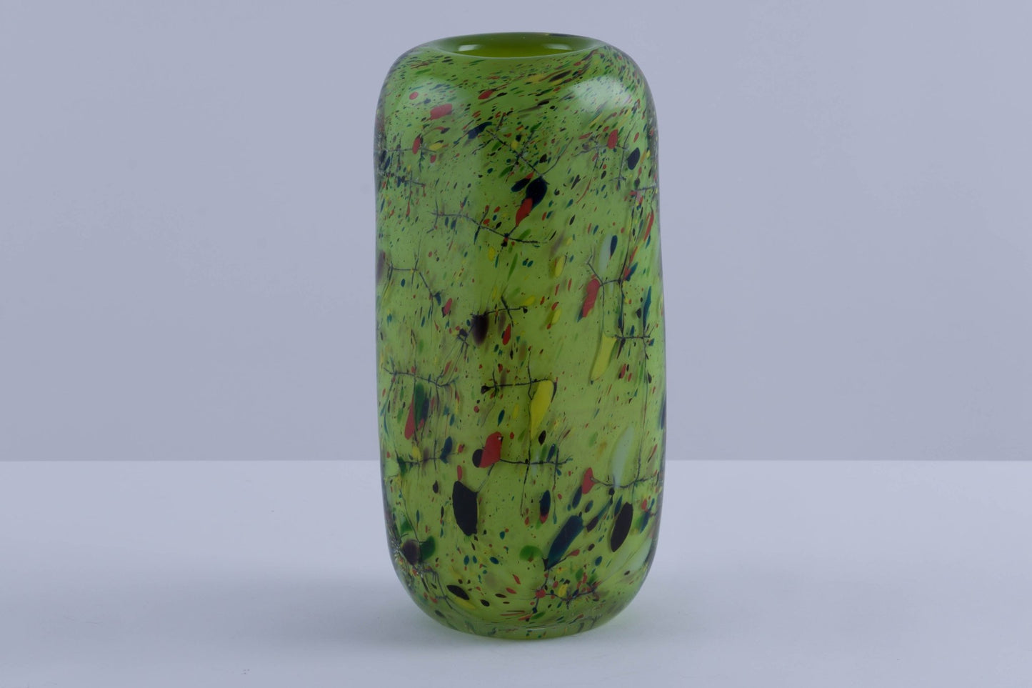Rectangular thick-walled colored glass vase with rounded edges and vibrant green with multicolor splatter pattern