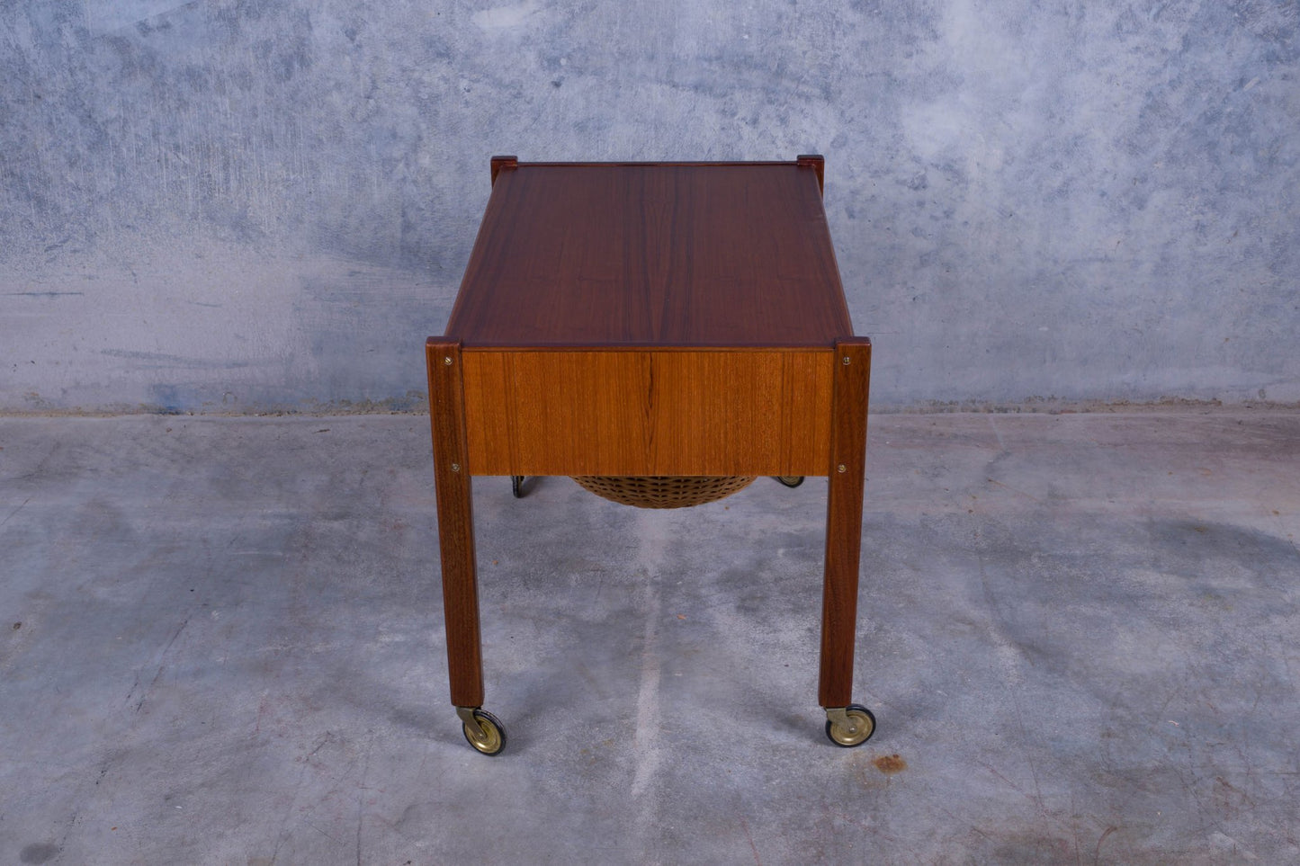 Rolling Danish teak sewing side table with pull-out drawer and caned circular slide-out container underneath