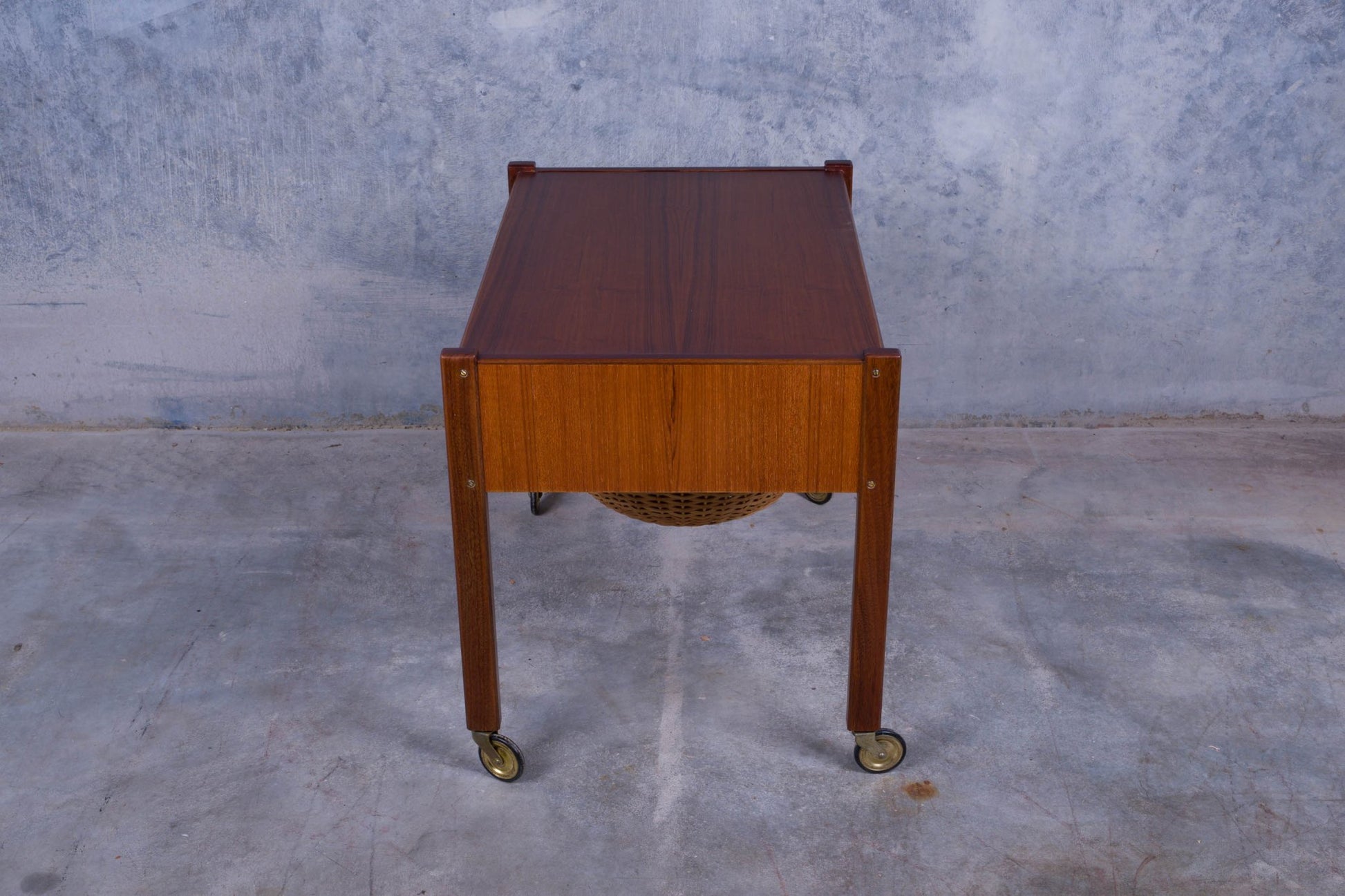 Rolling Danish teak sewing side table with pull-out drawer and caned circular slide-out container underneath