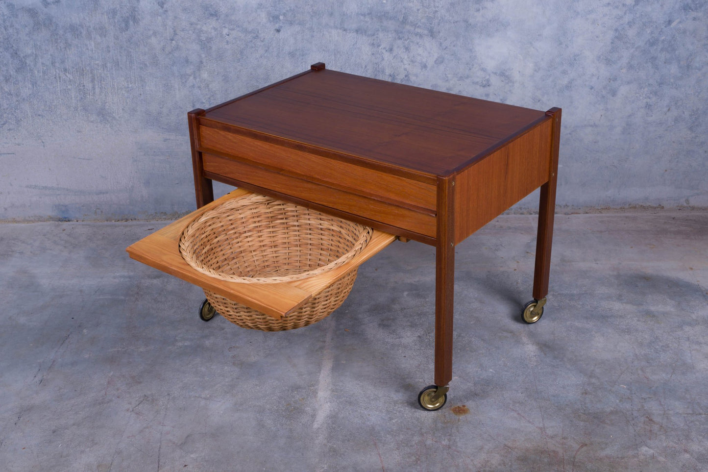 Rolling Danish teak sewing side table with pull-out drawer and slide-out caned circular basket on casters