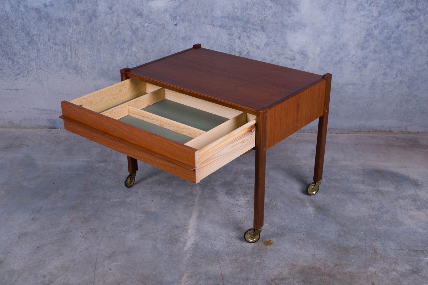 Danish teak sewing side table on casters with open pull-out drawer featuring section dividers and smooth wood finish