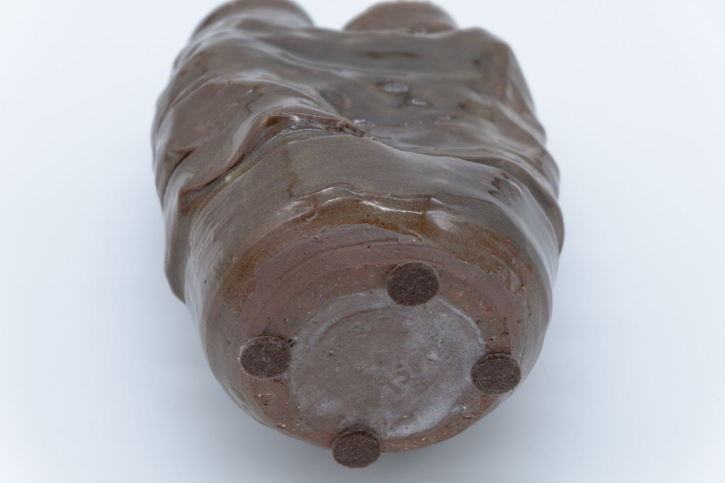 Bottom view of glossy dual neck studio pottery vase with irregular organic shape and artist signature on base