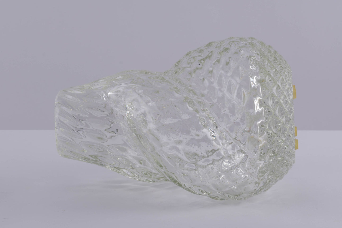 Asymmetrical spiral glass vessel by Flavio Poli with textured surface and clear transparent design on neutral background.