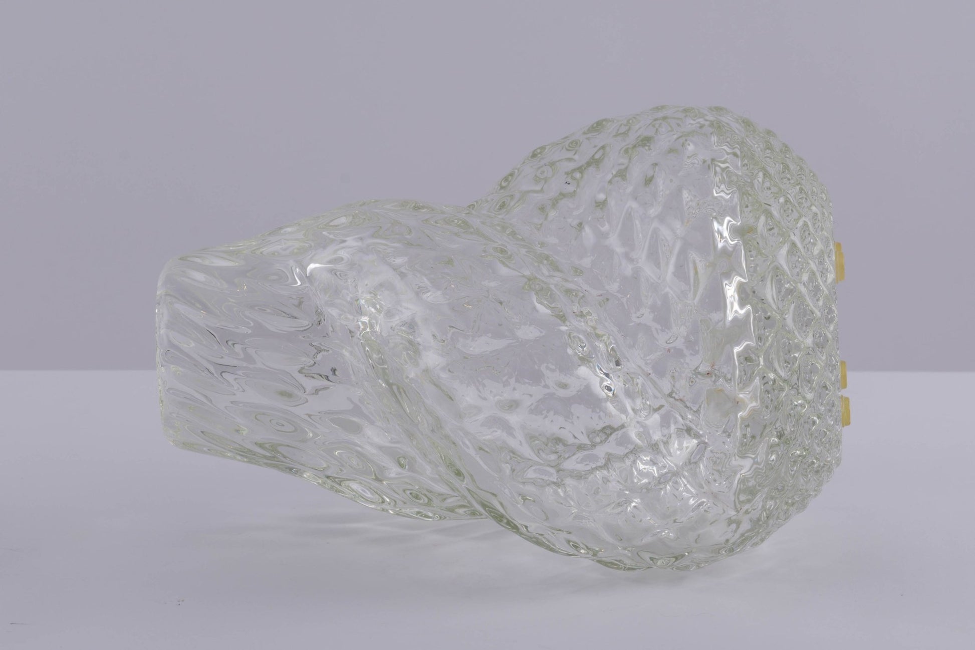 Asymmetrical spiral glass vessel by Flavio Poli with textured surface and clear transparent design on neutral background.