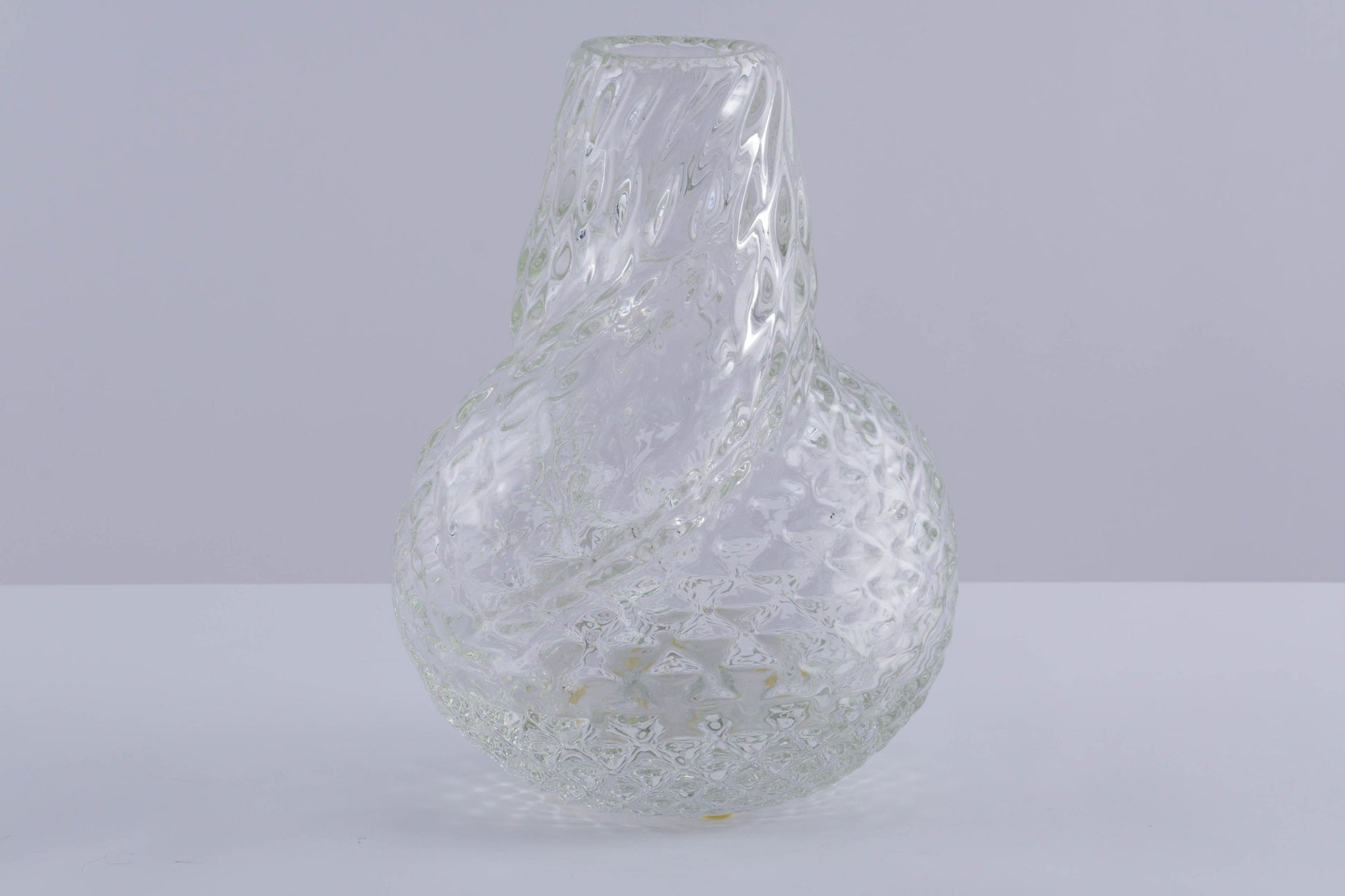 Spiral designed asymmetrical textured glass vessel by Flavio Poli with unique twisted form on light background