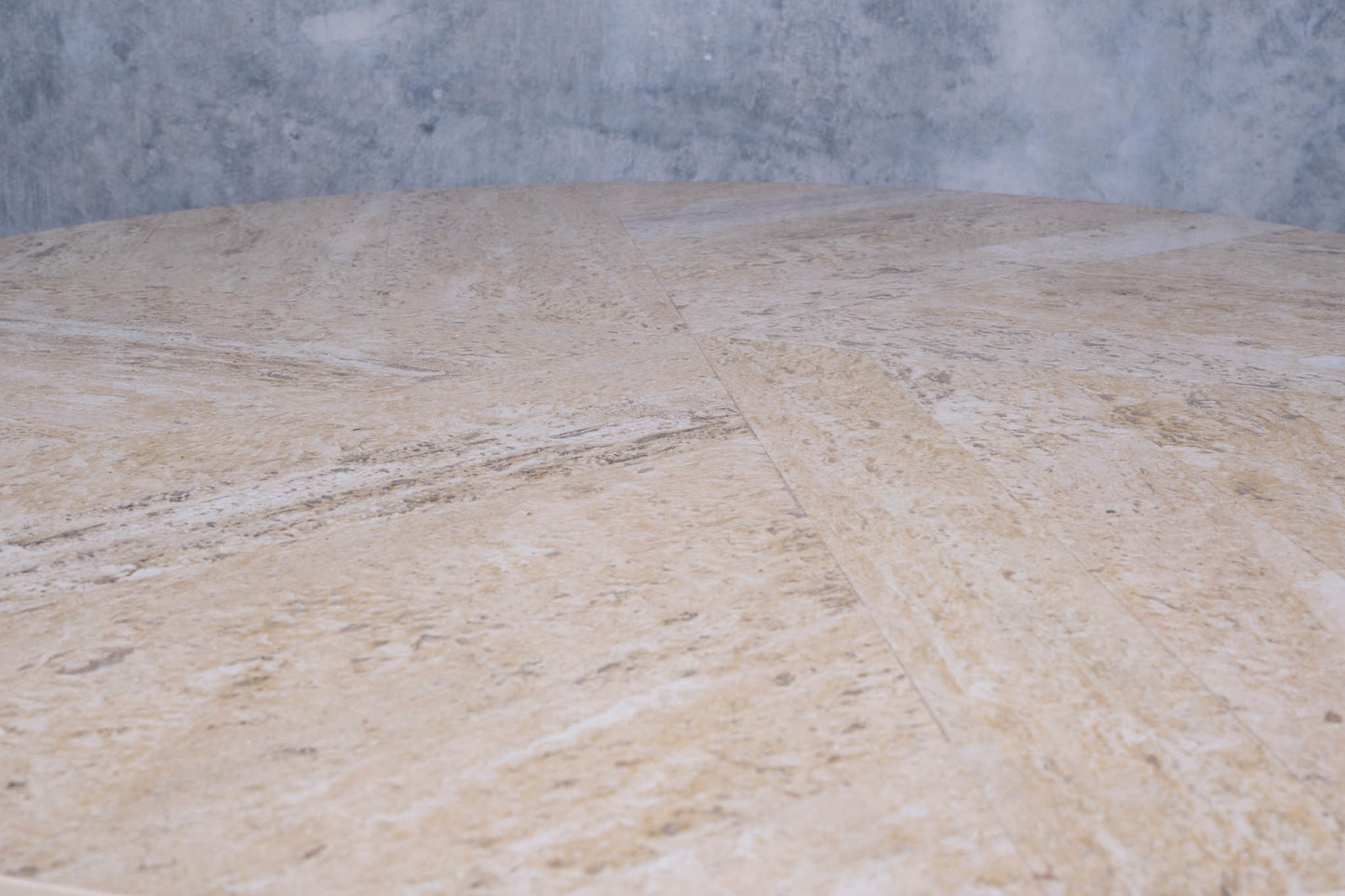 Close-up of circular travertine tabletop with inlaid spiral pattern on mid-century modern cocktail table