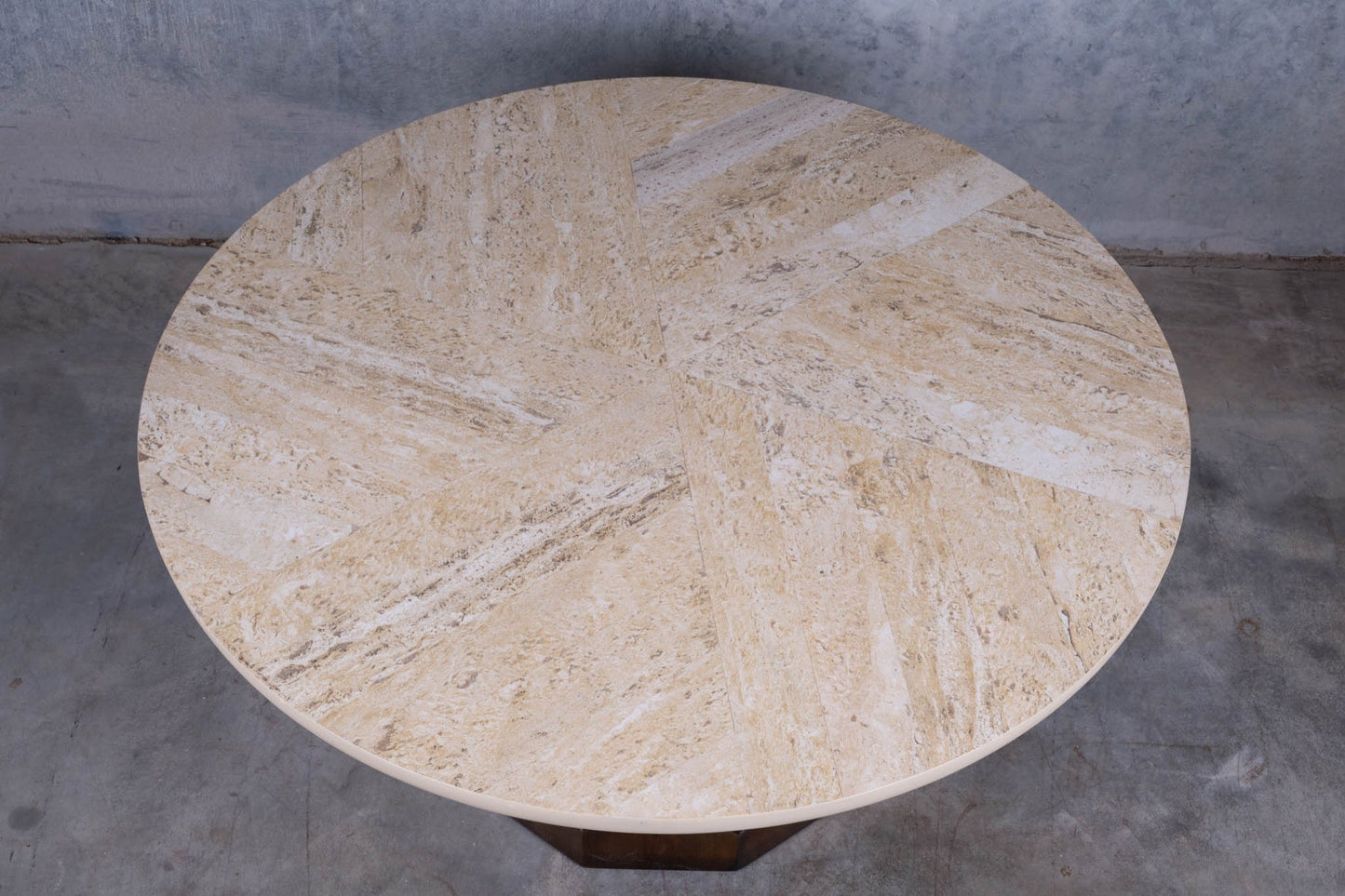 Circular mid-century modern cocktail table with travertine top featuring spiral inlay and carved mahogany base.