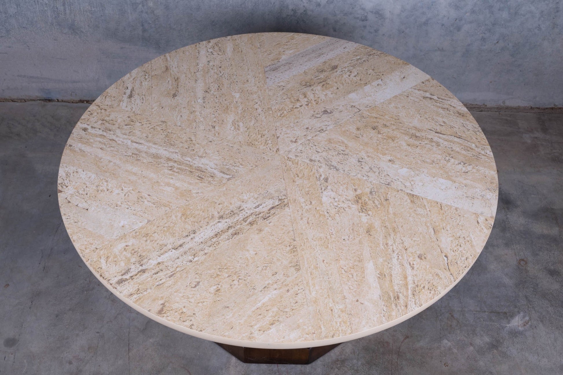 Circular mid-century modern cocktail table with travertine top featuring spiral inlay and carved mahogany base.