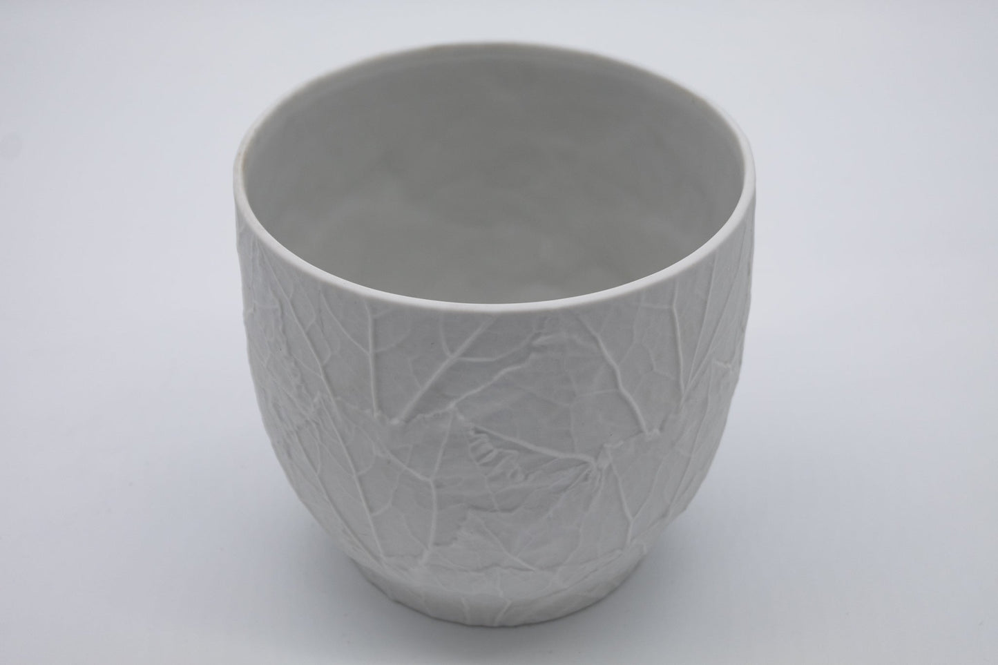 White Heinrich & Co. porcelain vase with raised leaf bisque texture and gently flared oval rim, 1950s vintage design.