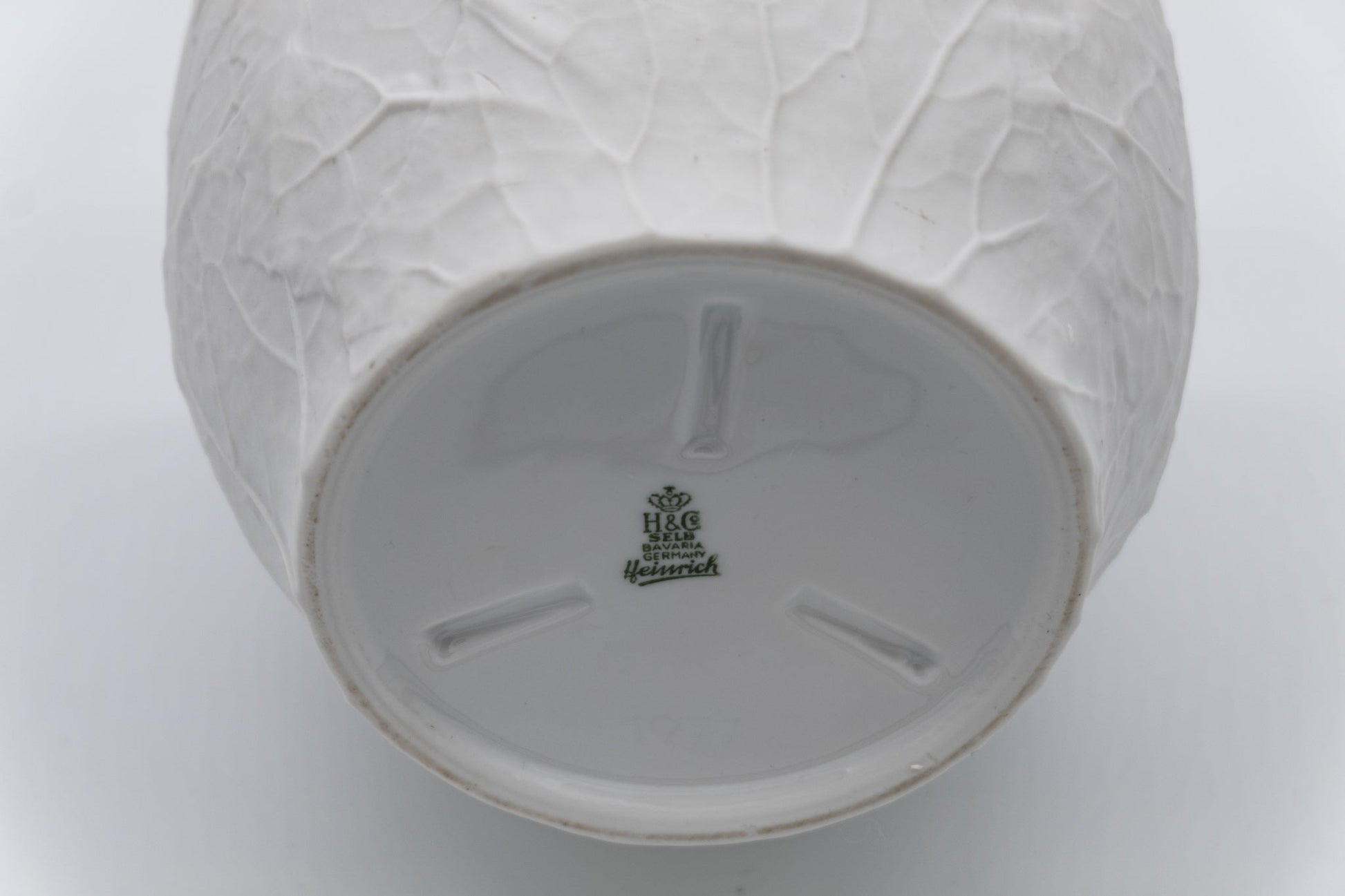 Base of Heinrich & Co. white porcelain vase with raised leaf bisque texture and green factory mark from Germany.