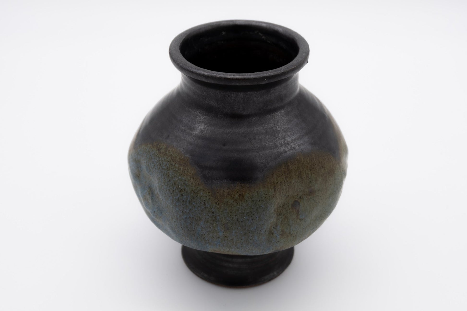 Spherical studio pottery vase with indented body and multi-colored glaze, signed on the bottom.