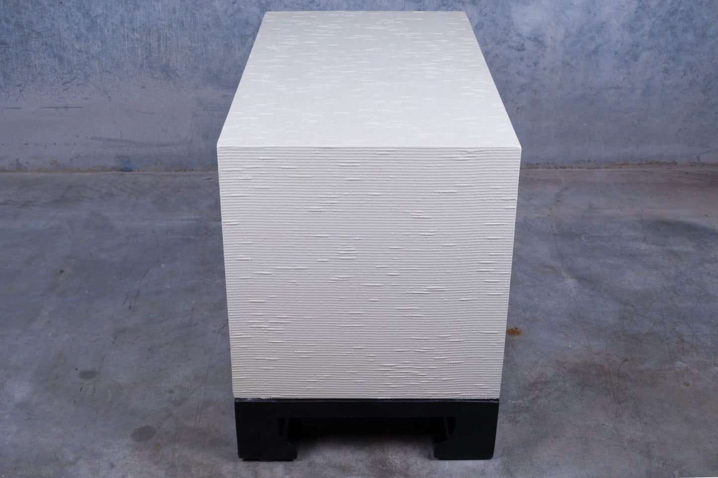 Three drawer James Mont style faux tortoiseshell dresser with white riveted surface and black lacquered carved base.