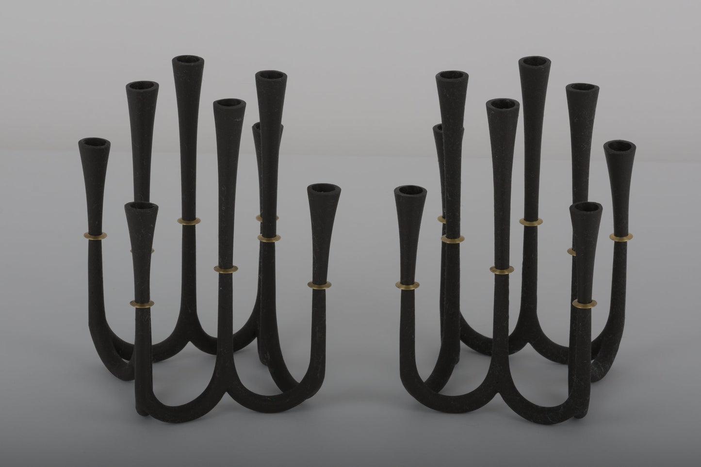 Pair of Jens Quistgaard cast iron candelabra candle holders with bronze accents designed for thin Dansk candles from the 1950