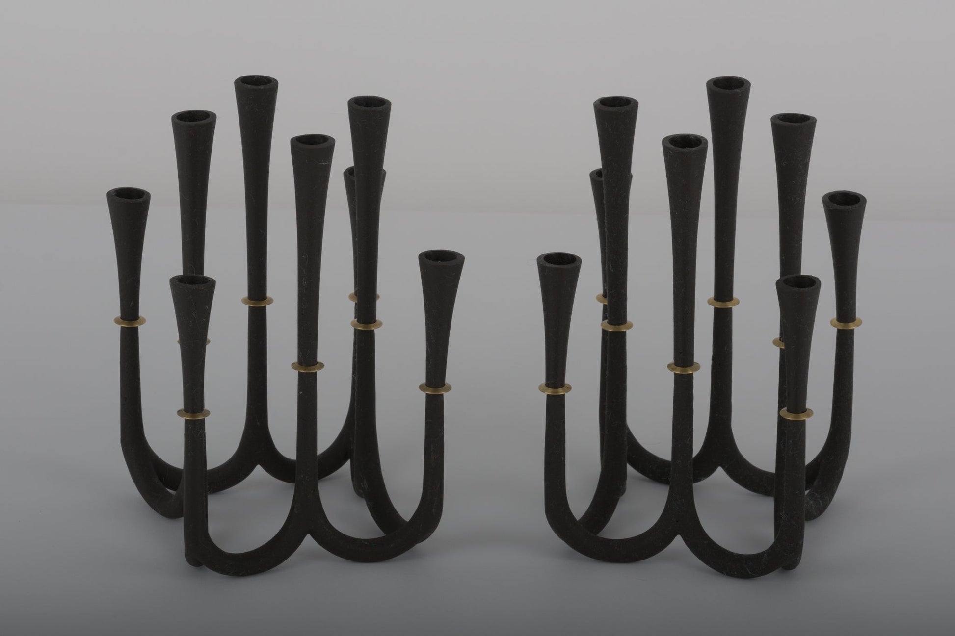 Pair of Jens Quistgaard cast iron candelabra candle holders with bronze accents designed for thin Dansk candles from the 1950