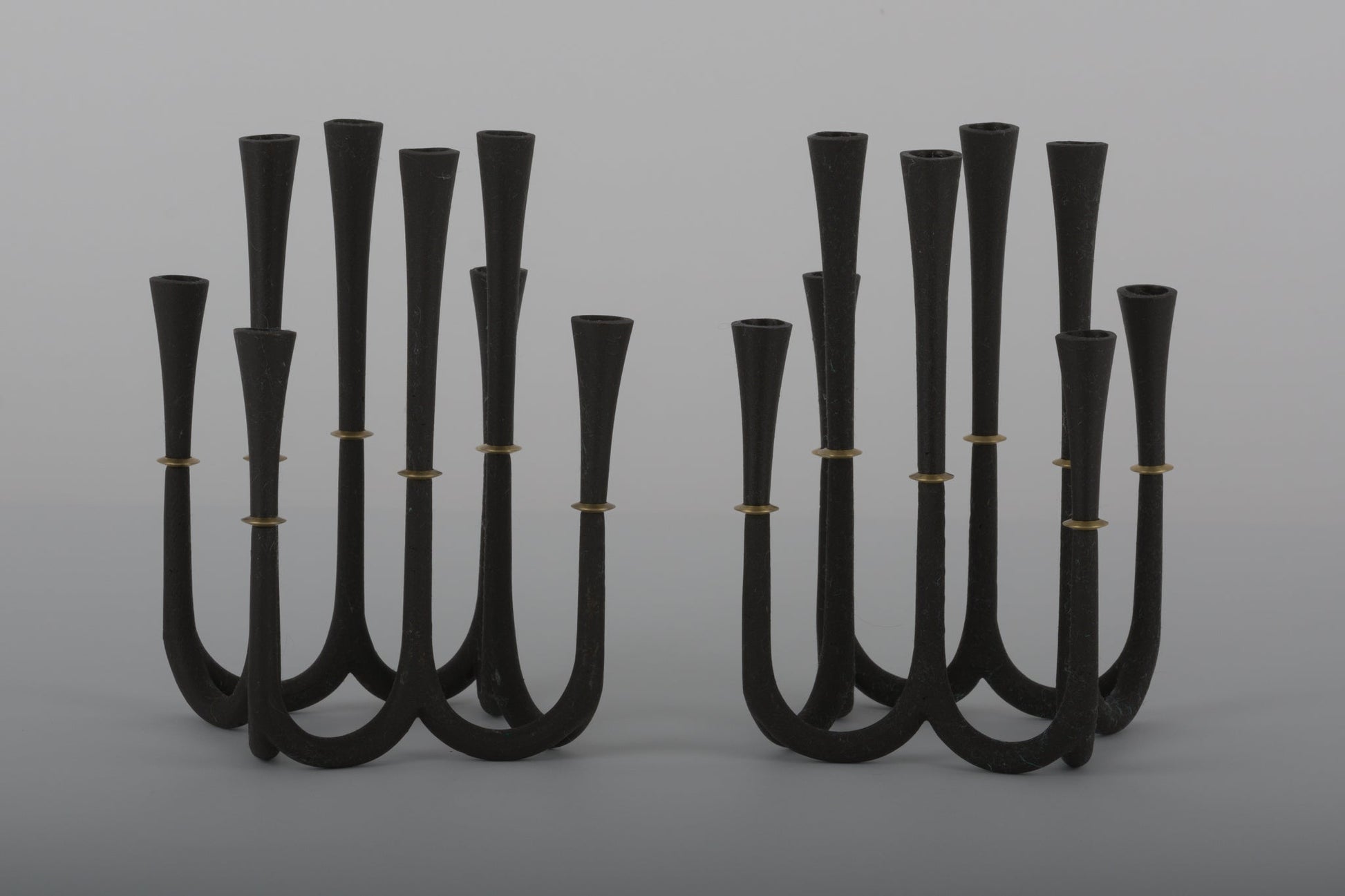 Pair of Jens Quistgaard cast iron candelabra candle holders with bronze accents designed for thin Dansk candles from 1950s