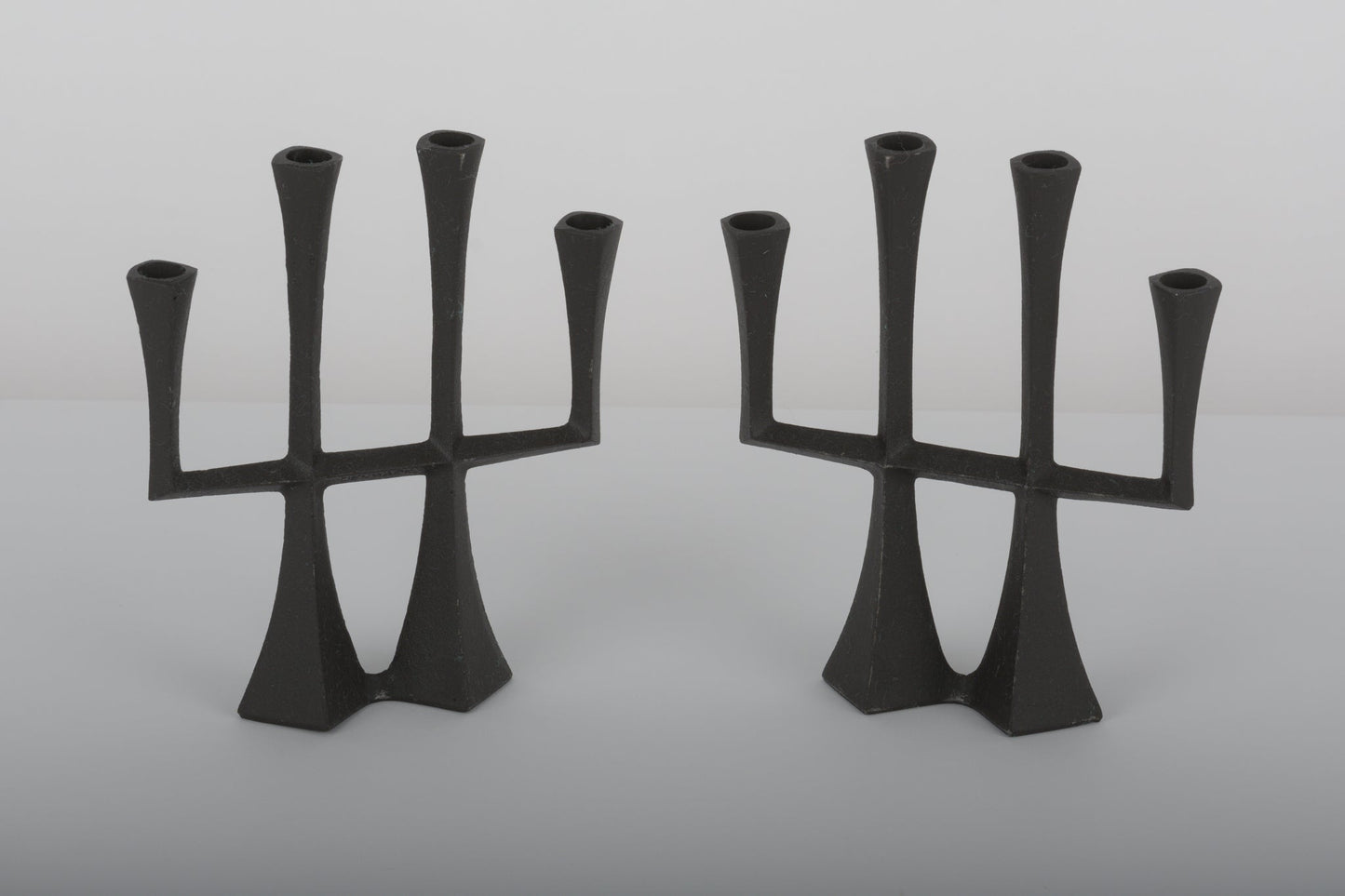 Pair of Jens Quistgaard cast iron Danish candle holders from the 1950s with three arms and sculptural design