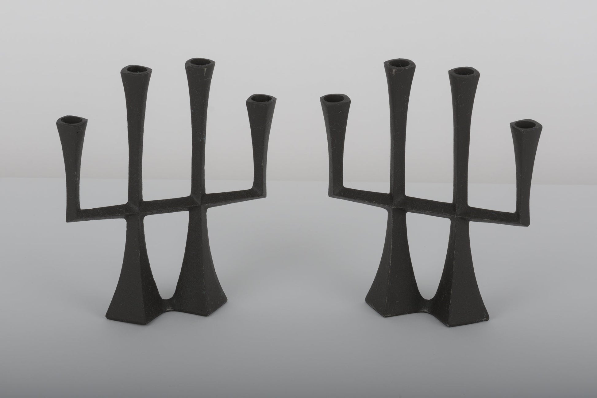 Pair of Jens Quistgaard cast iron Danish candle holders from the 1950s with three arms and sculptural design