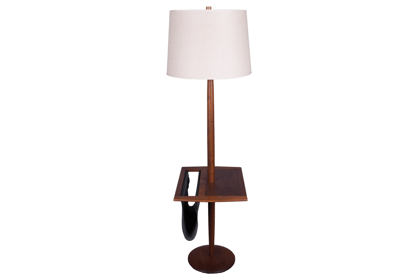 Mid-century modern wooden floor lamp with built-in side table and black leather magazine sling on round base.