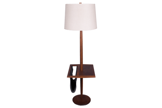 Mid-century modern wooden floor lamp with built-in side table and black leather magazine sling on round base.