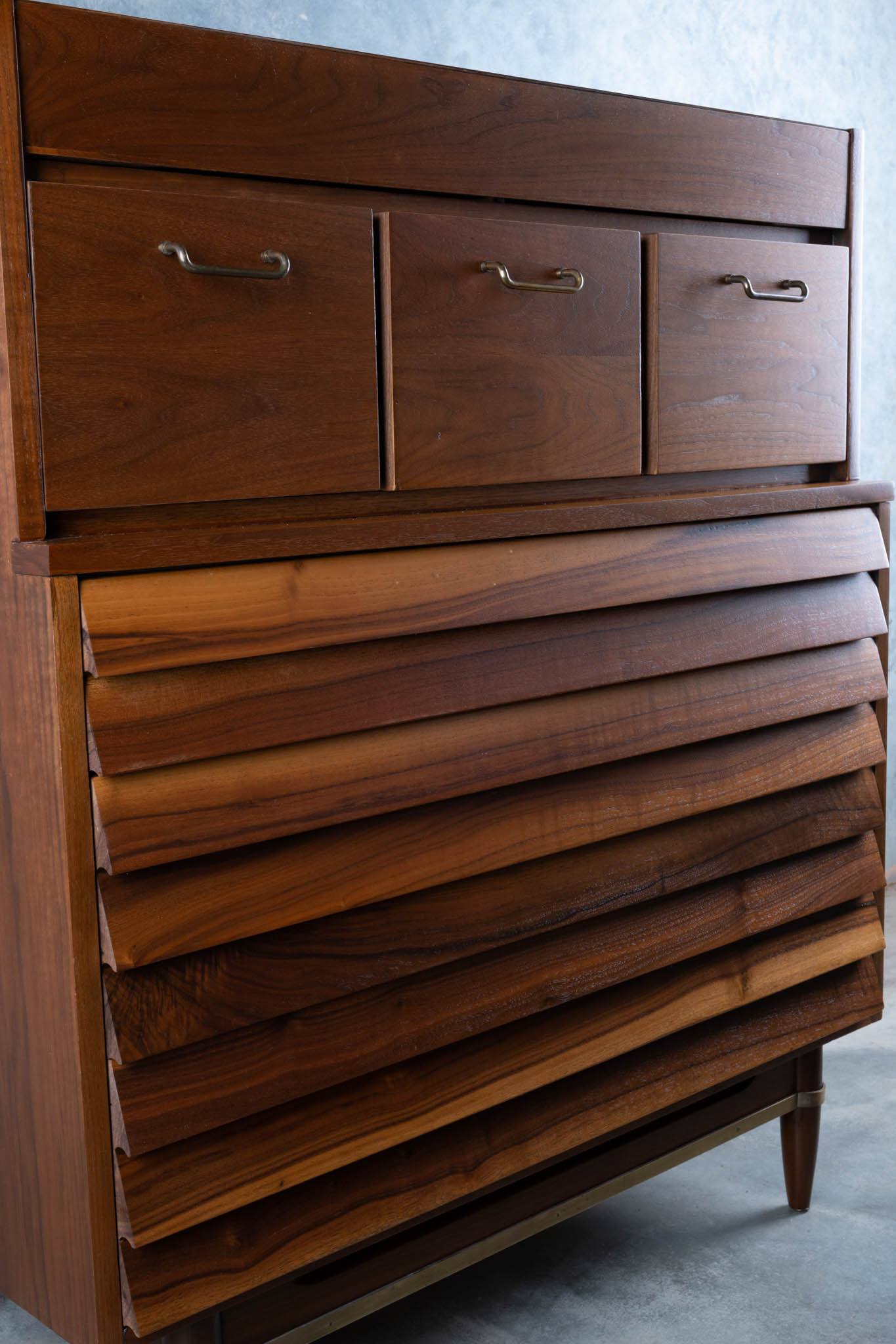 Mid-century modern walnut highboy dresser with louvered drawers and brass handles designed by Merton L. Gershun.