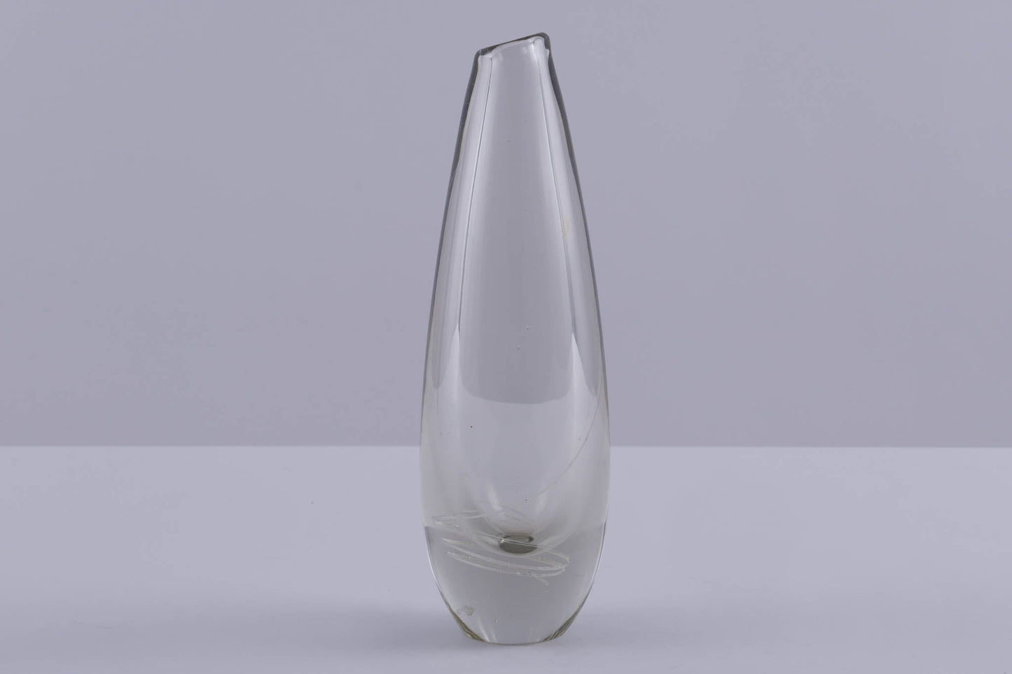 Mikko Helander glass vase with inlaid spiral pattern, slim tapered shape, and clear Scandinavian design on grey background.