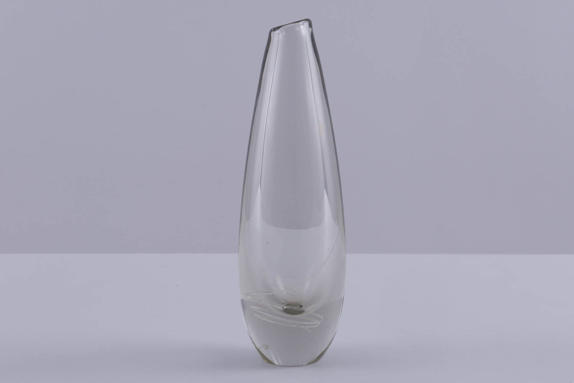 Mikko Helander glass vase with inlaid spiral pattern, slim tapered shape, and clear Scandinavian design on grey background.