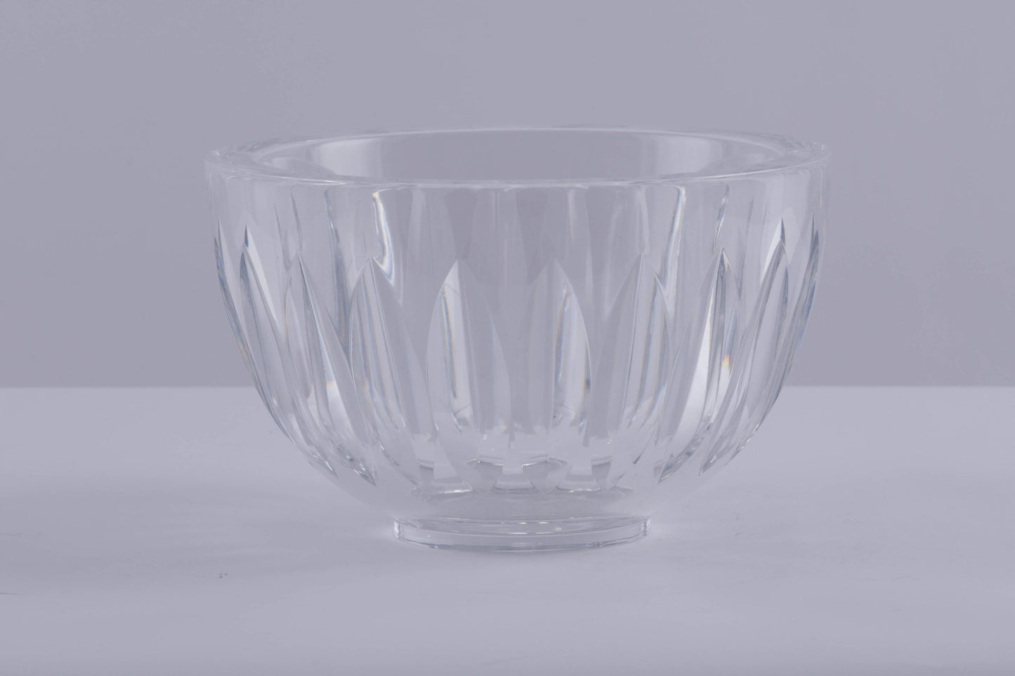 Orrefors heavy cut crystal bowl with wedge-shaped cuts creating prismatic light reflections, designed by Sven Palmqvist