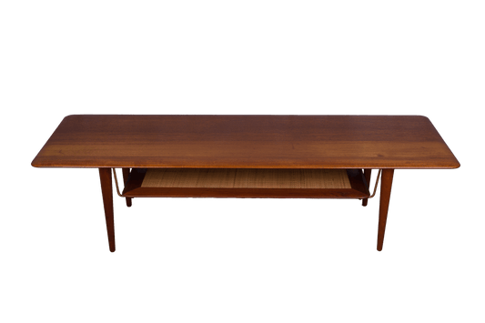 Mid-century modern teak coffee table by Peter Hvidt and Orla Molgaard-Nielsen with cane shelf and tapered legs.