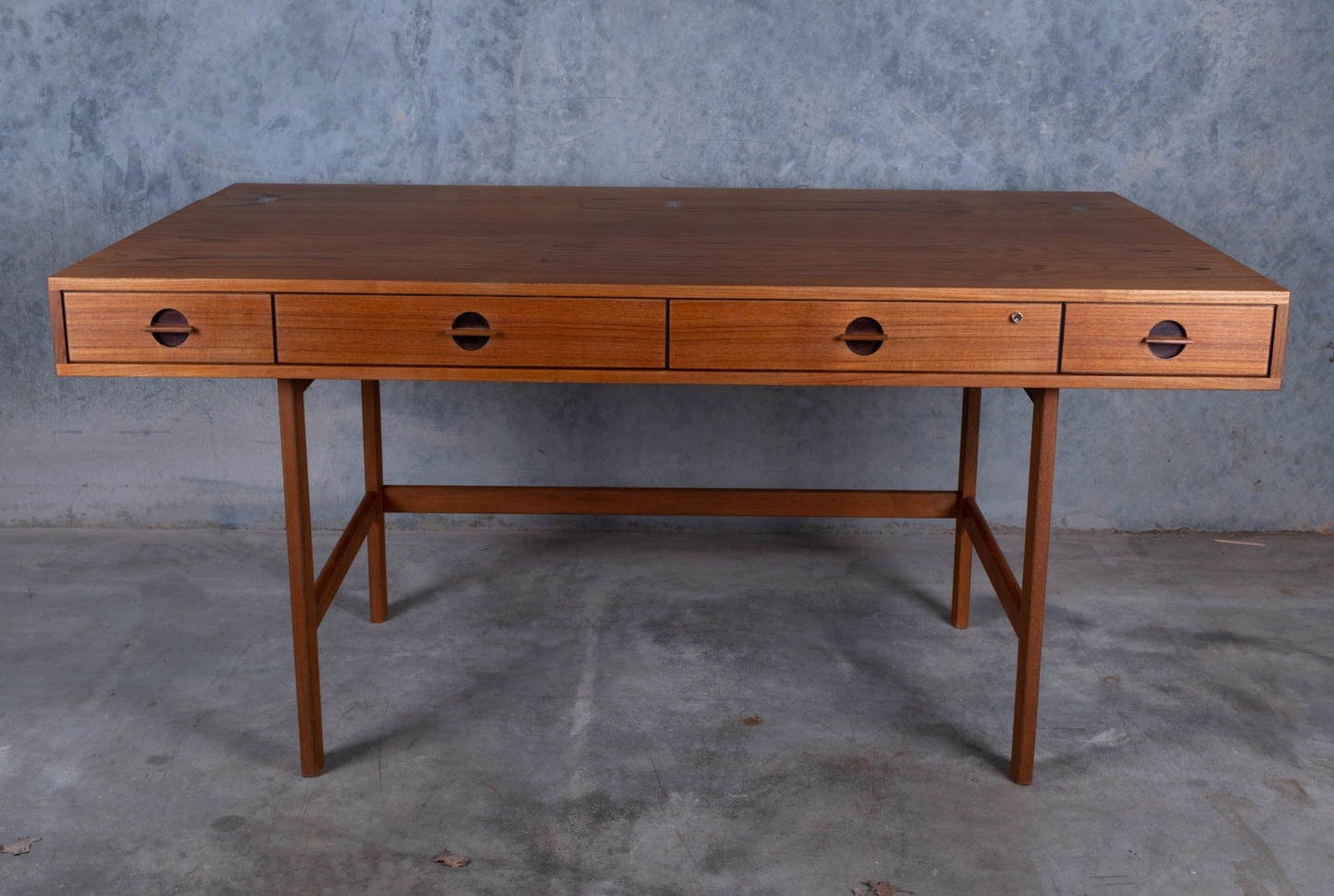 Mid-century modern rosewood flip-top desk by Peter Lovig Nielsen with four drawers and clean lines on concrete background