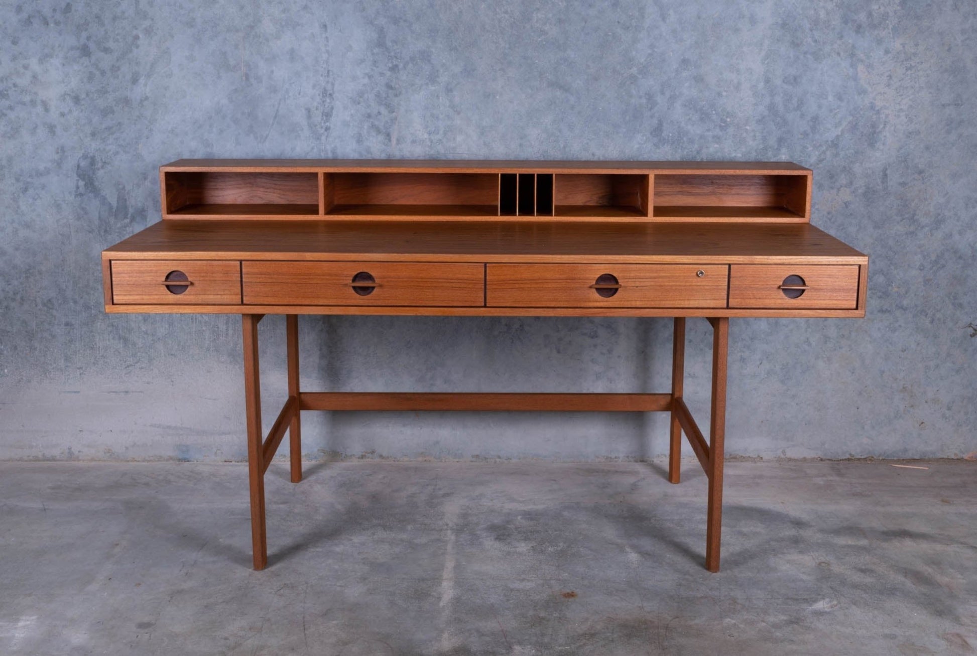 Mid-century modern Peter Lovig Nielsen rosewood desk with flip-top storage, four drawers, and open shelving on slender legs.