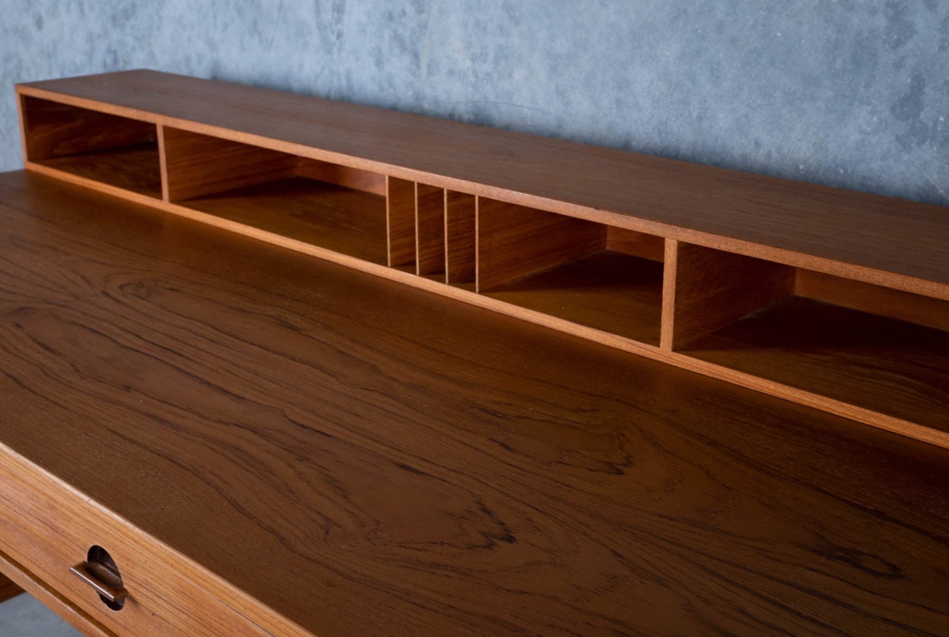 Close-up of mid-century modern Peter Lovig Nielsen rosewood desk with built-in compartments and wood grain detail