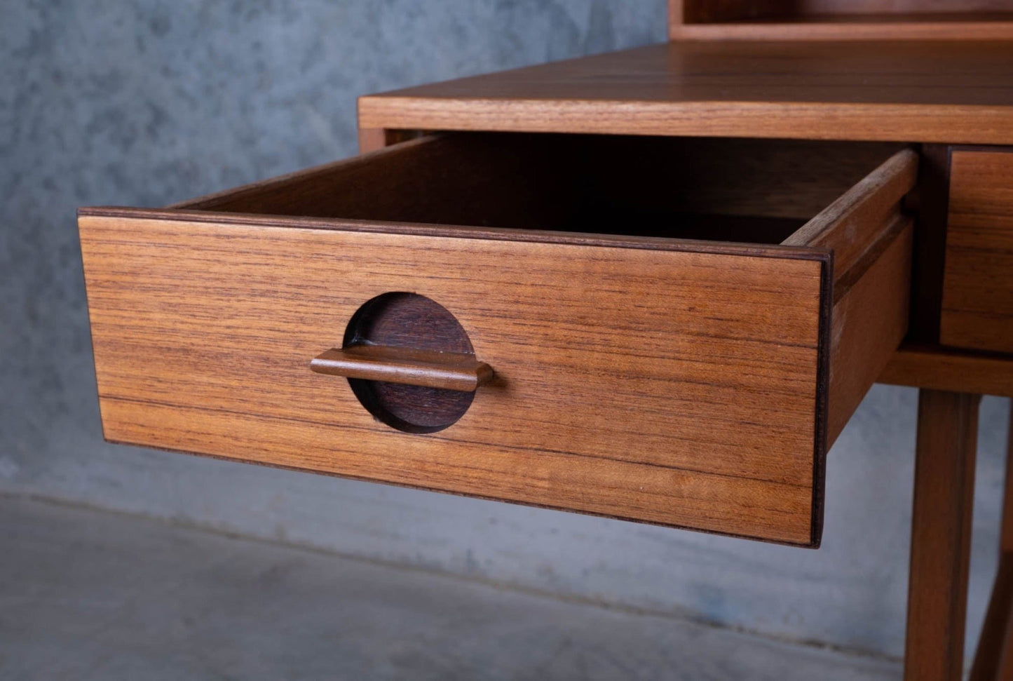 Open drawer of Peter Lovig Nielsen mid-century modern rosewood desk showing minimalist round handle detail