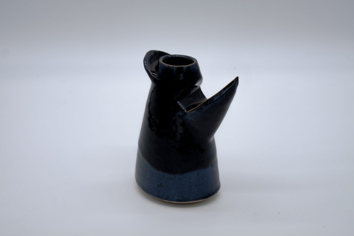 Studio pottery art vase with a tapered cylindrical chamber in blue and black glaze featuring sculptural protrusions.