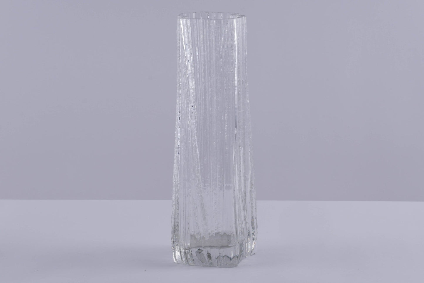 Tall clear Rosenthal Studio Line Ice Glass Vase with textured ice pattern by Martin Freyer on neutral background