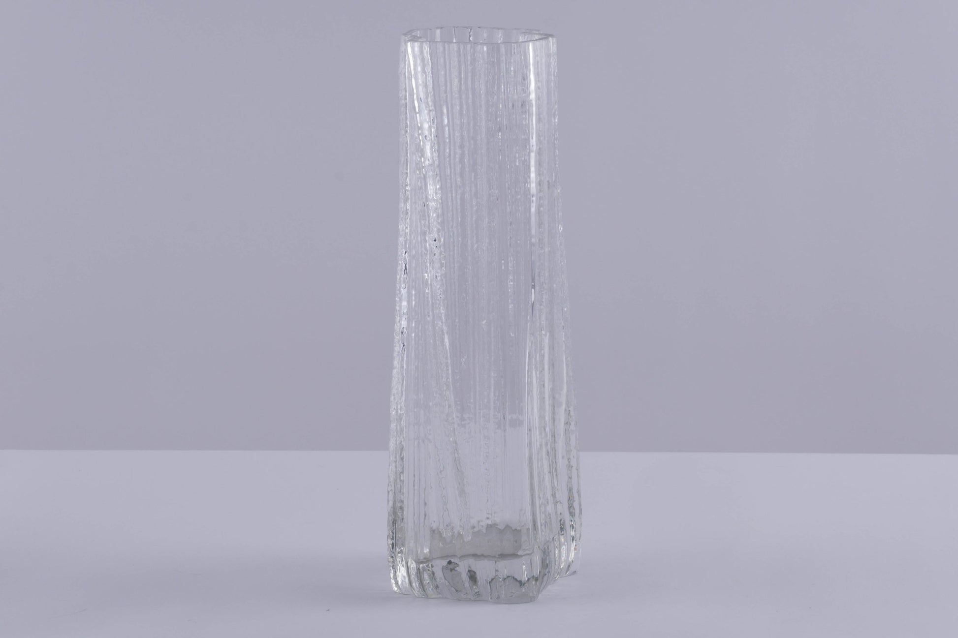 Tall clear Rosenthal Studio Line Ice Glass Vase with textured ice pattern by Martin Freyer on neutral background