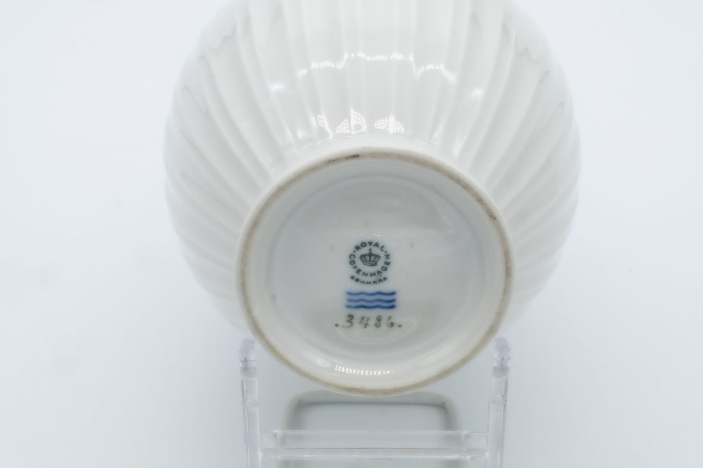 Underside of Royal Copenhagen white fluted porcelain vase showing maker’s mark and model number 3486 on stand